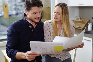 Young,Couple,Planning,For,A,New,Home,Standing,In,A
