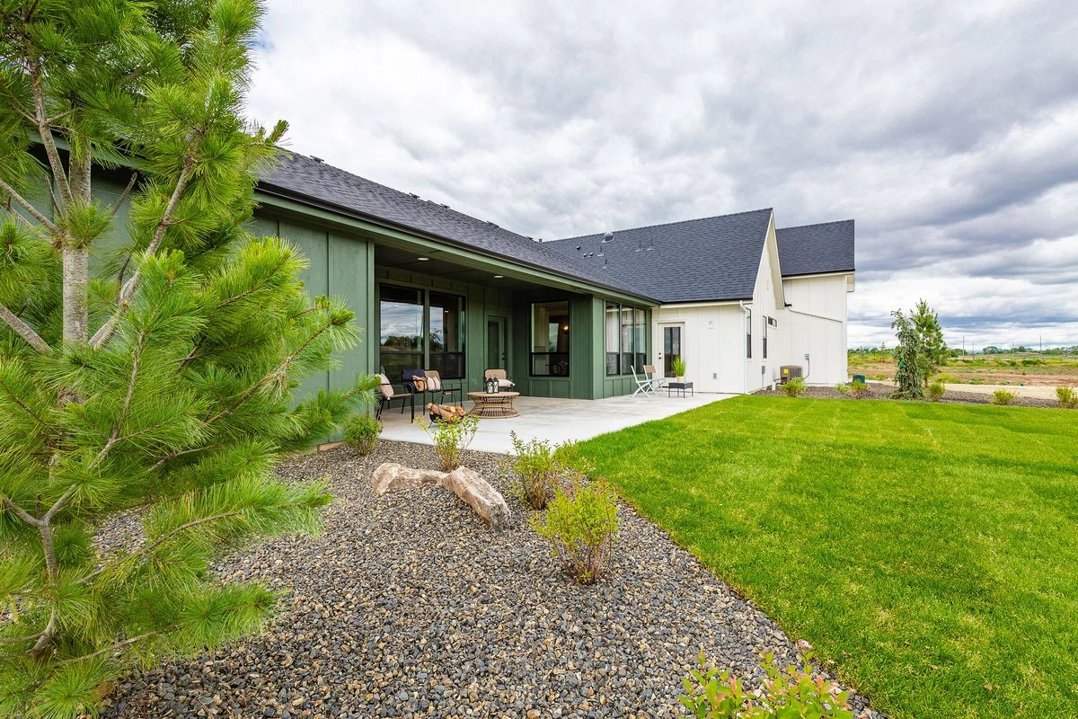 Boise custom home with a covered back patio and landscaped yard
